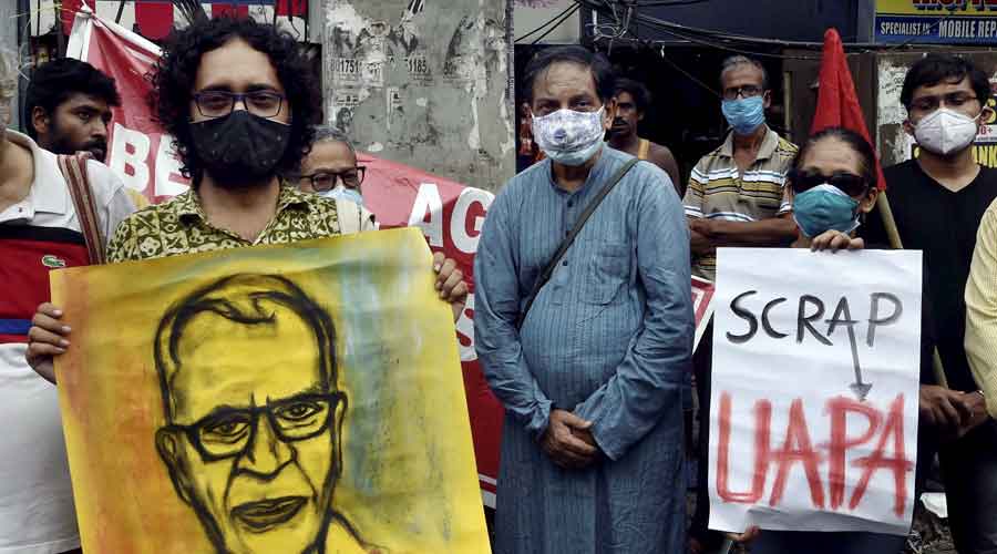 CPI(ML) activists hold a poster stage a protest over the death of Father Stan Swamy, in Kolkata