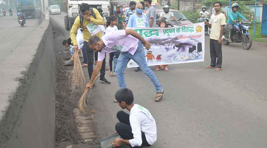 Members of social outfits Youth Concept during the cleaning drive on Jharia-Dhanbad road at Bhagtdih Jharia on Thursday.