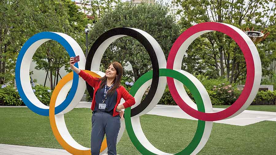 A girl takes a selfie in front of Olympic Rings in Tokyo. 