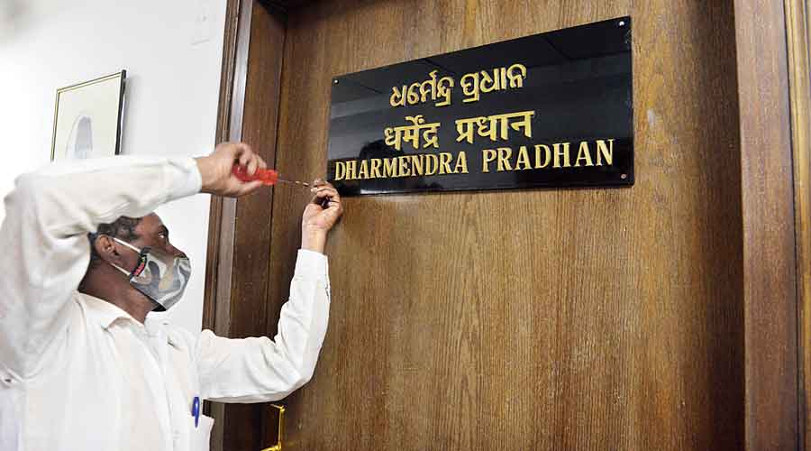 A worker fixes the nameplate of education minister Dharmendra Pradhan at Shastri Bhavan on Thursday. 