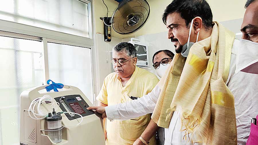 Minister Sujit Bose checks out one of the four oxygen concentrators handed over to the hospital on Doctors Day by the Rotary Club of Aarohee Calcutta. Hospital superintendant Partha Pratim Guha is to the right.