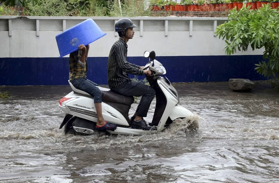 Commuters make their way through a water-logged road after heavy rain in Amritsar on Monday.