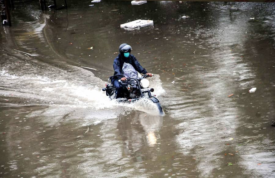 A commuter wades through a waterlogged road at Chandani Chowk in Patiala on Tuesday.