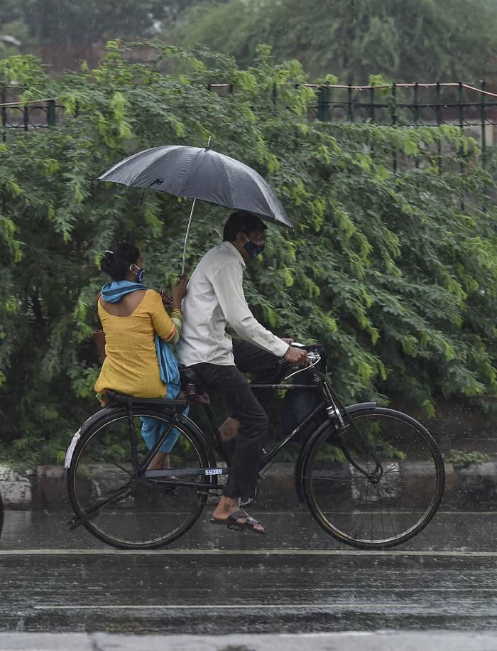 Commuters carry an umbrella during rain as monsoon reaches New Delhi, on Tuesday.