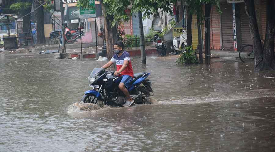 A biker negotiates waterlogged Kalimati Road at Sakchi in Jamshedpur on Sunday afternoon.