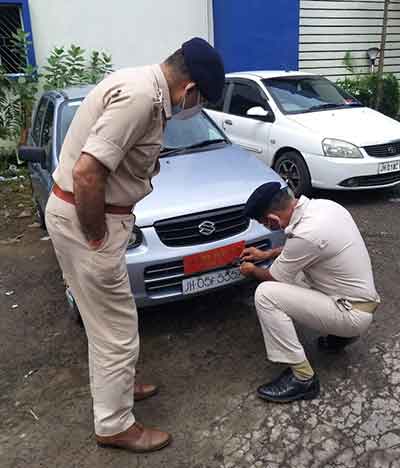 Two traffic cops take a VIP plate off a car at Sakchi on Friday.