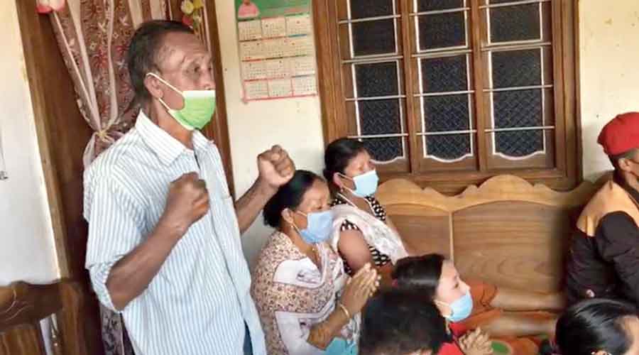 Chanu’s father Saikhom Kriti cheers for his daughter as the family watches her event on television at their home in Imphal East in Manipur.
