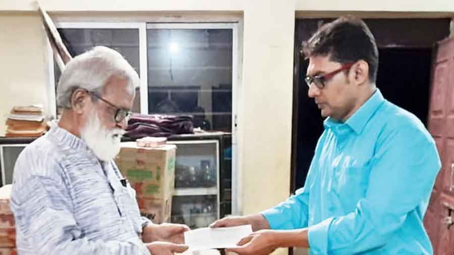 Debasish Sarkar, a friend of Abhigyan Mukherjee, hands over the cheque on behalf of Mukherjee’s schoolmates to Kamal Chakraborty, the co-founder and secretary of Bhalopahar School
