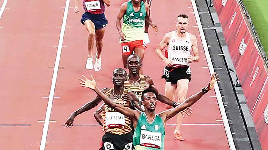Gold medallist Selemon Barega of Team Ethiopia celebrates as he crosses the finish line ahead of Uganda’s Joshua Cheptegei (silver) and Jacob Kiplimo (bronze) in the men’s 10,000m final at the Olympic Stadium on Friday. 