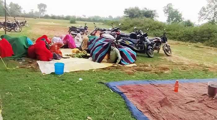 The wedding guests take shelter under mats and bedsheets to remain safe from bees in Hazaribagh on Monday.
