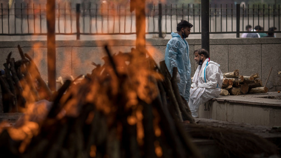 A man performs the last rites for his wife who died of the Covid-19 coronavirus disease during a mass cremation at a crematorium on April 20, 2021 in New Delhi, India.