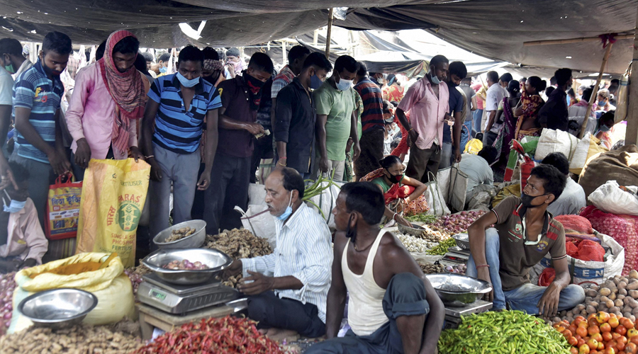  People, not adhering to social distancing norms, purchase necessary items at a village market after relaxation of COVID-19 lockdown norms, in South Dinajpur district of West Bengal on Sunday.