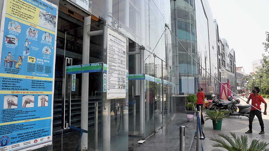 A worker sprays disinfectant to sanitise a mall ahead of its reopening as the unlocking process of the Covid-19 lockdown begins in New Delhi on Sunday. 