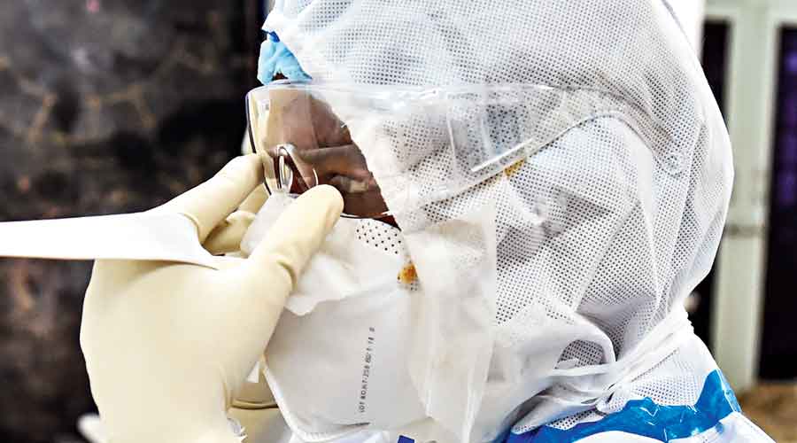 A nurse adjusts her eye shield before entering the  Covid ward