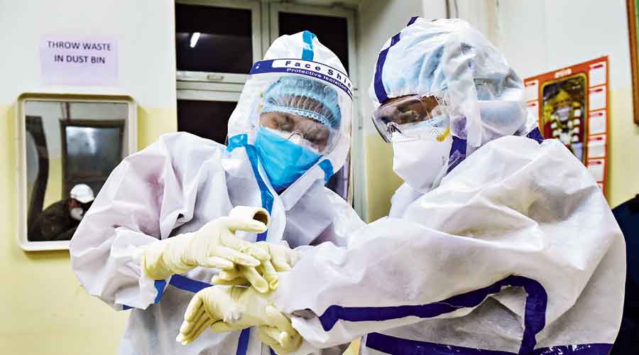 A nurse helps her colleague  get ready for ward duty