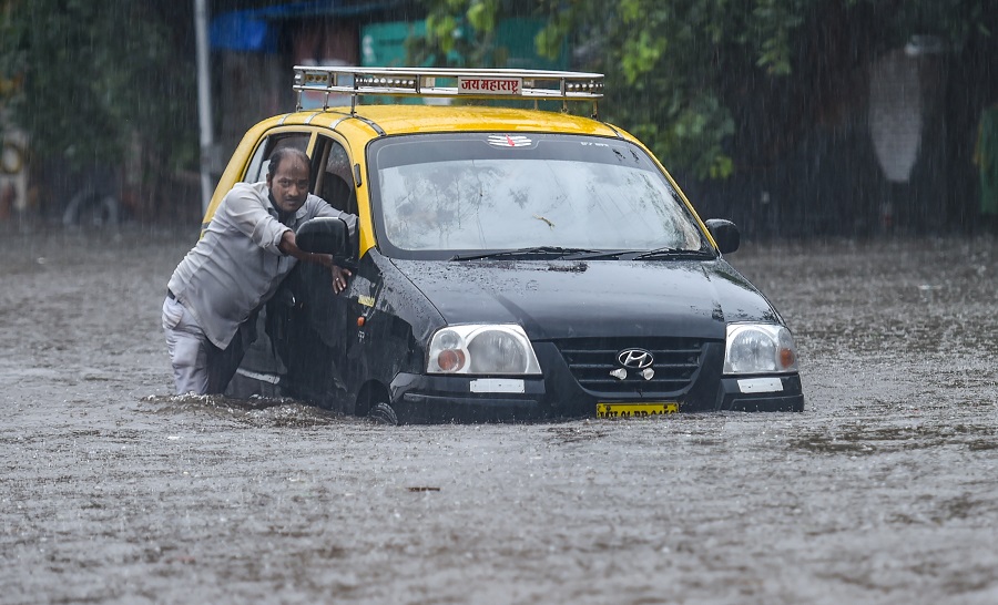 A taxi driver pushes his car as he tries to wade through a waterlogged street at Hindmata in Mumbai on Wednesday.