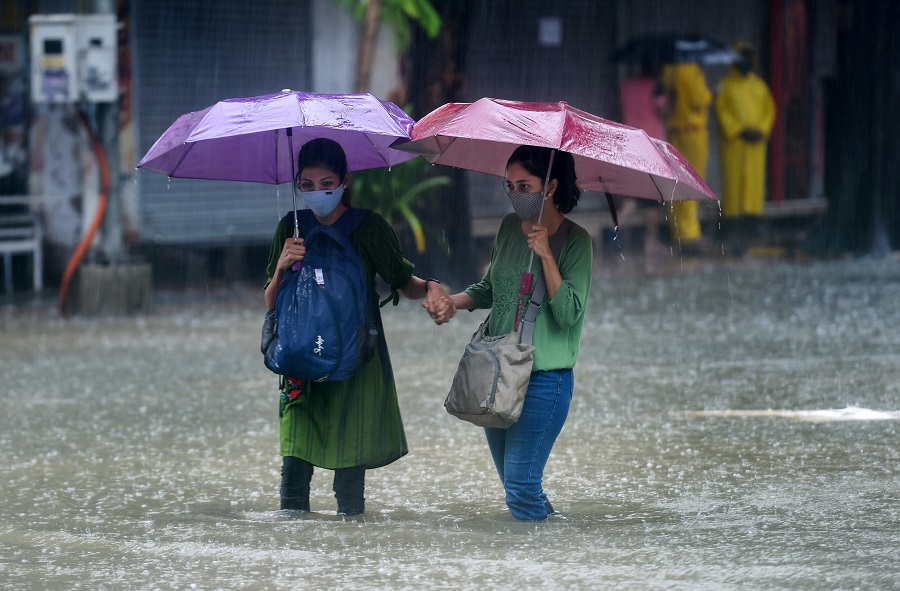 People wade through a waterlogged street at Hindmata in Mumbai on Wednesday.