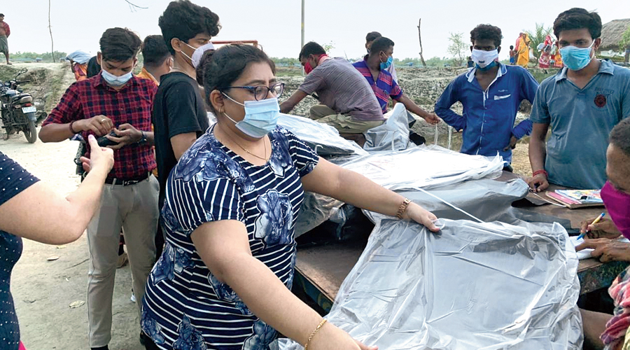 A team from the school distributes the material at the camp in Kultali, Sunderbans.