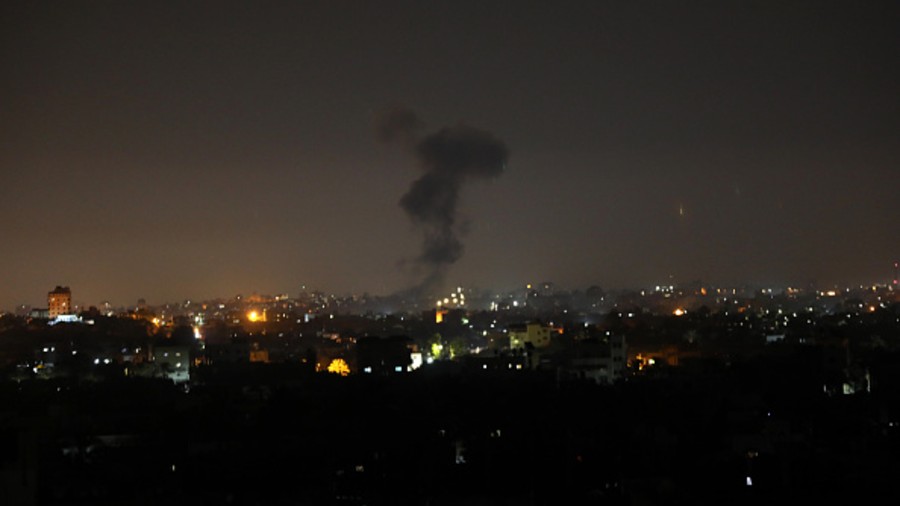 Explosions light-up the night sky above buildings in Gaza City as Israeli forces shell the Palestinian enclave, early on Wednesday