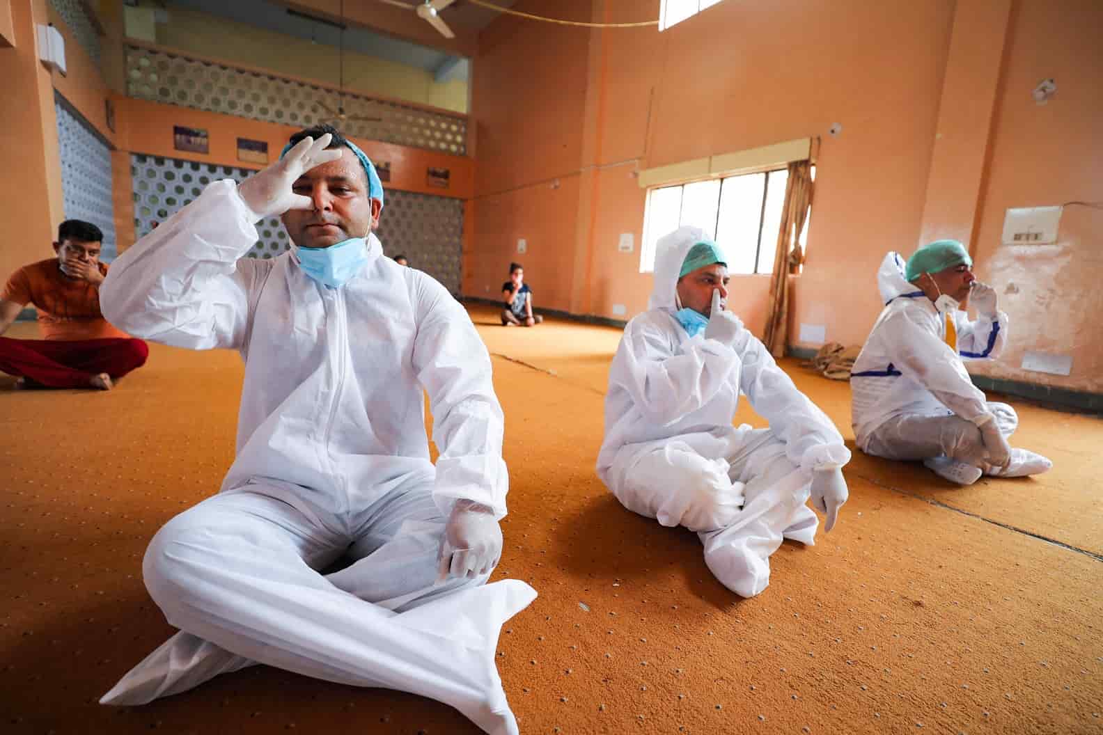 Health workers and patients in PPE engage in Yoga on International Yoga Day eve at a Covid care centre in  Jammu.