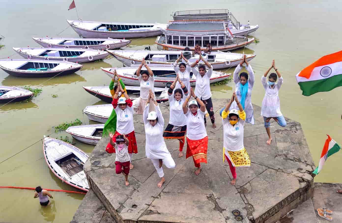 Women and children do asanas at Ganga Ghat in Varanasi on Sunday.