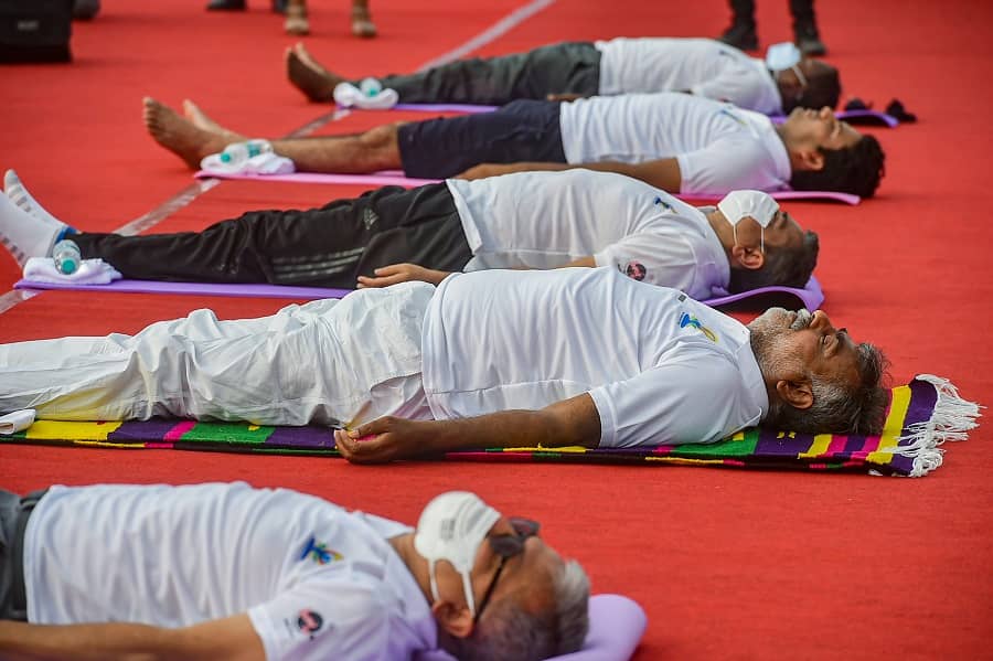 Culture and Tourism Minister Prahlad Singh Patel with others perform Yoga on International Day of Yoga at Red Fort in New Delhi on Monday