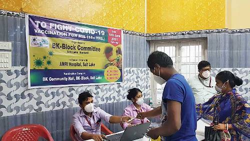 Officials help out with formalities at the BK Block vaccination camp.