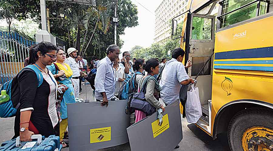 Election officials board a  bus during the 2019 Lok Sabha polls. 