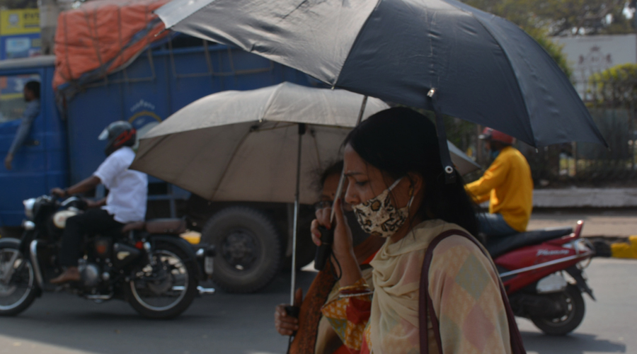 Pedestrians use umbrellas to protect themsleves from the sun at Sakchi in Jamshedpur on Tuesday. 