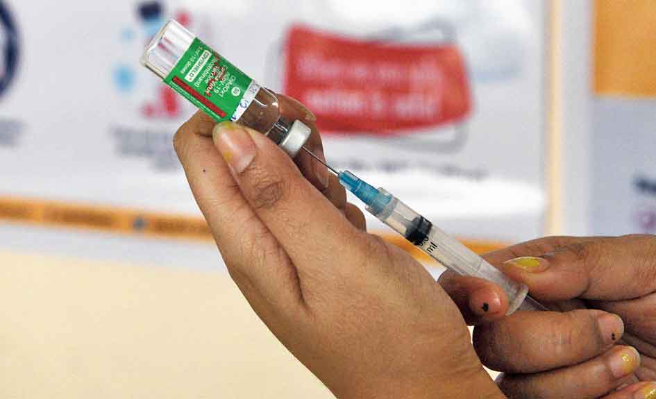 nurse prepares a Covishield vaccine shot.