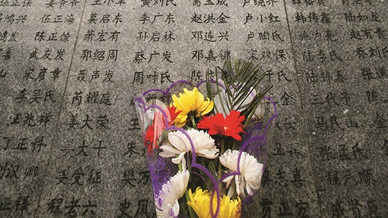 Flowers are laid in front of a wall engraved with names of victims who died in the Nanjing Massacre of 1937, during a ceremony to mark the 70th anniversary, at the Memorial Hall of the Victims in the Nanjing Massacre on December 13, 2007 in Nanjing of Jiangsu Province, China. Japanese troops occupied the former captial city of Nanjing on December 13, 1937 and launched a six-week long massacre of over 300,000 Chinese soldiers and civilians.