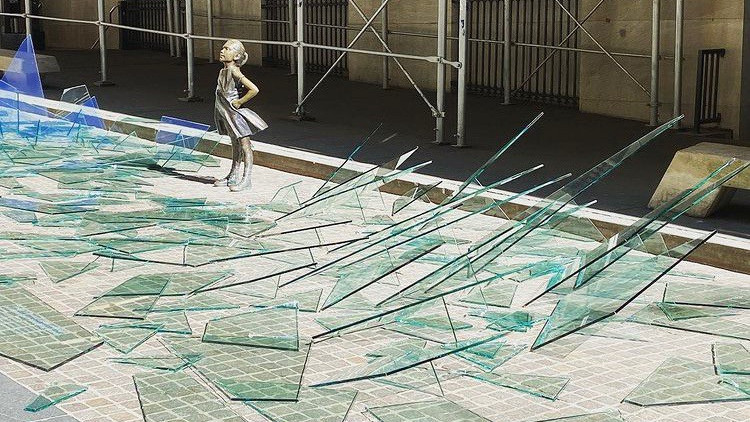 A broken glass ceiling installation by State Street Global Advisors surrounds The Fearless Girl statue, as the world marks International Women's Day, outside the New York Stock Exchange (NYSE) in New York.