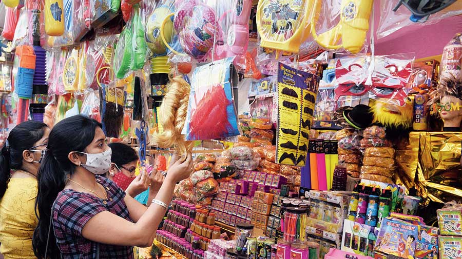 People buy colours and other items ahead of Holi from a shop at Satyanarayan Park on Thursday. 