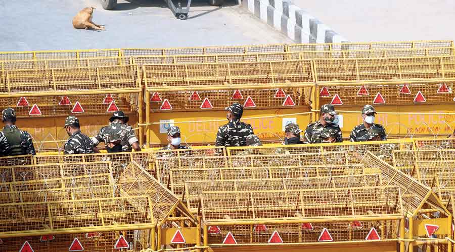 Policemen stand next to the barricades  at Delhi’s Ghazipur border on Friday