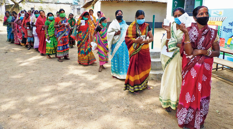 Women wait to cast their votes in Bankura on Saturday. 