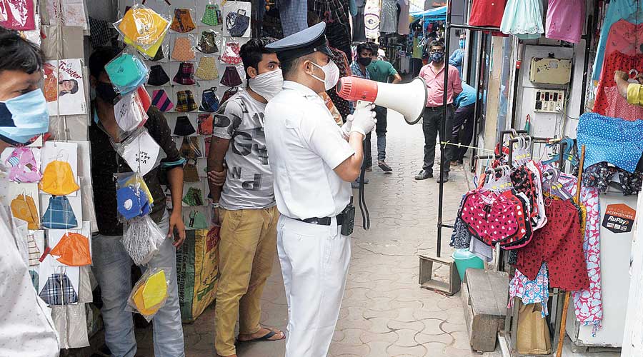 A cop urges Garihat hawkers who had kept their stalls open  even after 10am to shut shop.