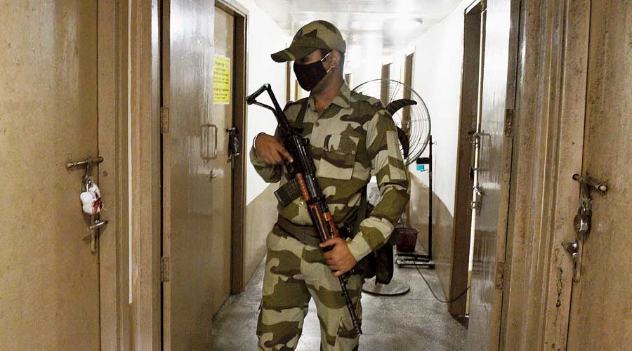 A jawan stands guard outside a strong room at the Netaji Indoor Stadium. 