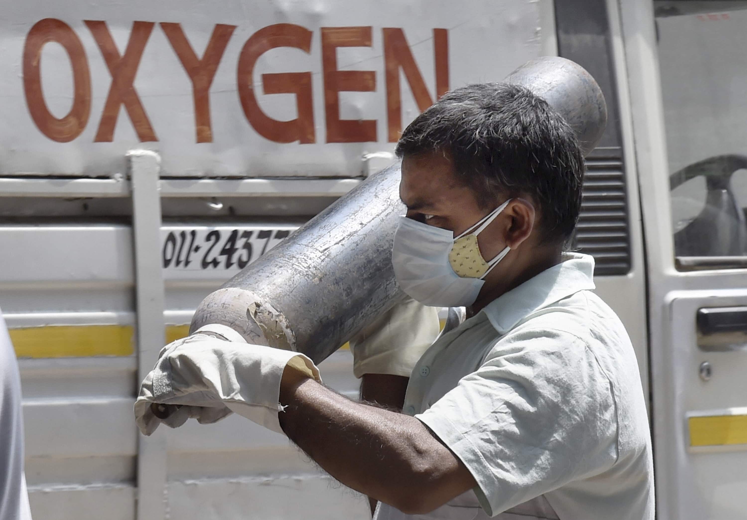 A family member of a Covid-19 patient carries an oxygen cylinder from a refiling centre, in New Delhi, on May 8.