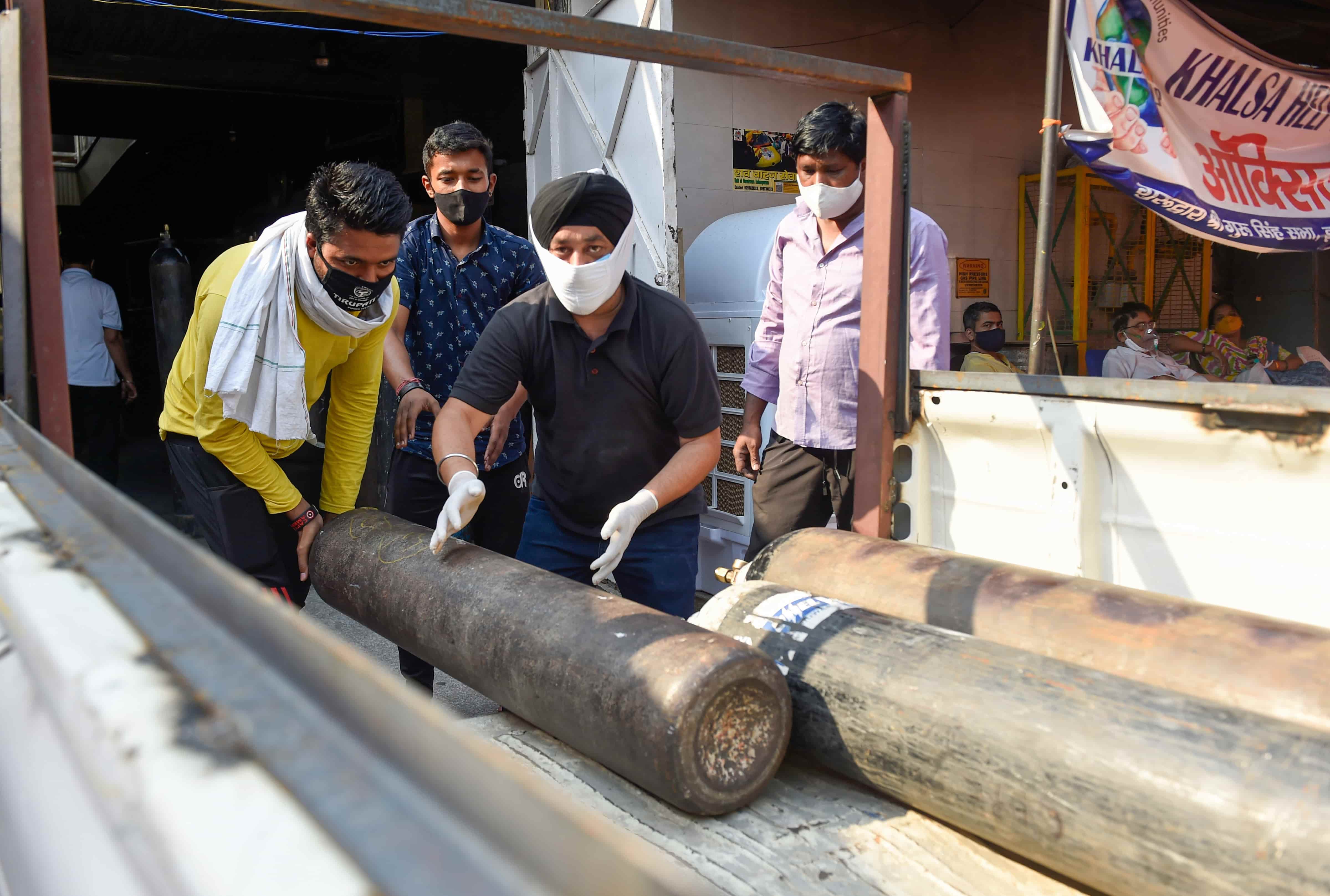 A health worker loads an empty oxygen cylinder in Indirapuram, Ghaziabad, on May 8.