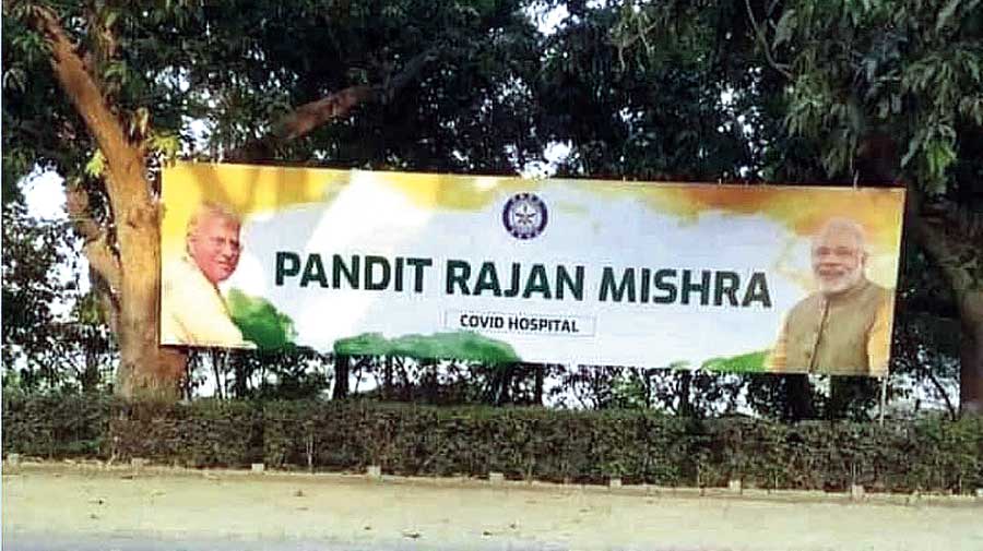 A board featuring the photographs of Pandit Rajan Mishra and Prime Minister Narendra Modi announces the naming of the hospital after the musician