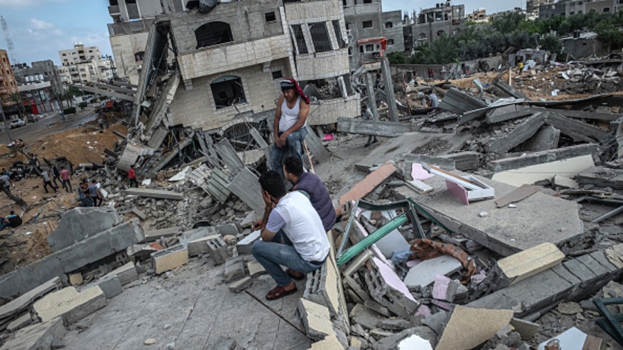  Some men sit on the rubble of a residential building in Gaza City, Gaza Strip, that was destroyed by an Israeli airstrike.