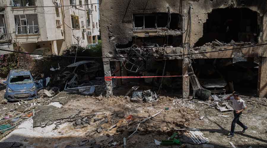 A person walks among the rubble of a destroyed building in Petah Tikva, Israel on Thursday, May 13, 2021, after it was hit by a rocket fired from Gaza Strip overnight. (Dan Balilty/The New York Times)