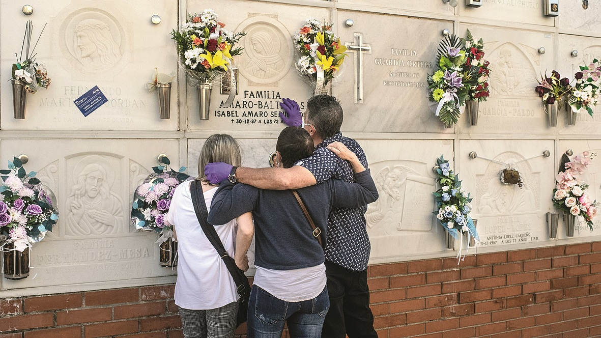 Francisco Baltanas (R) comforts his two sisters Isabel (C) and Maria del Carmen as they say their last goodbye during the funeral of their mother, Rafaela Carrillo, who died on March 26 due to a COVID-19 infection at the age of 85, at the cemetery of Sabadell on May 31, 2020 in Sabadell, Spain.