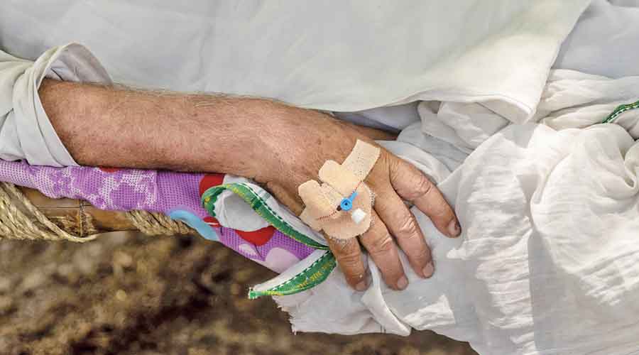 Harveer Singh, 65, suffering from Covid-19, rests in a cot at the makeshift open-air clinic.