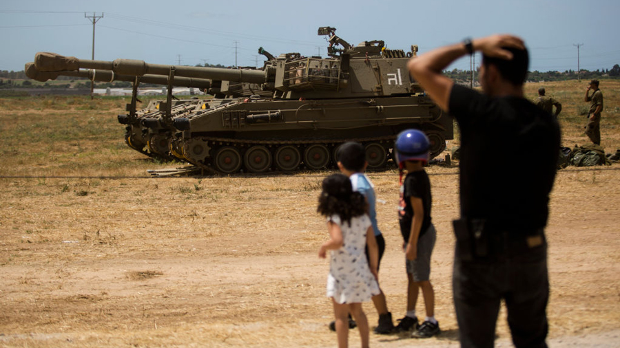 Israeli man and his kids look at Israeli tanks after Israel and Hamas agreed on a ceasefire on May 21, 2021 in Sderot, Israel. Yesterday, Israel's cabinet and Hamas, the militant group that rules Gaza, agreed on a ceasefire starting in the early hours of this morning. The recent fighting began on May 10th after rising tensions in East Jerusalem.