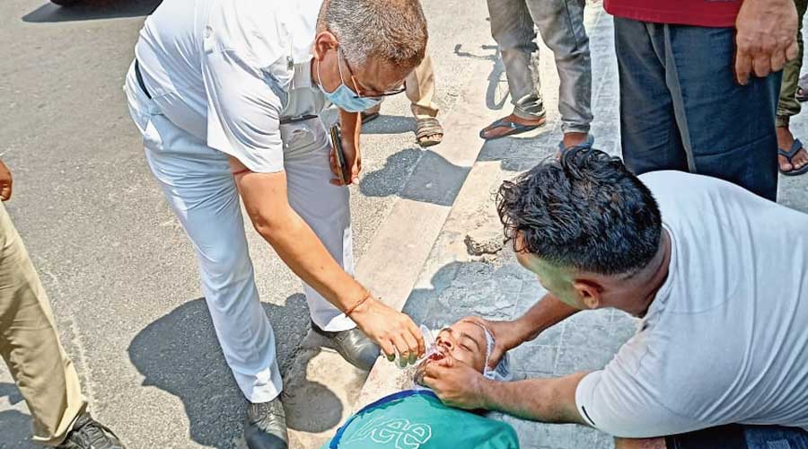 Suvamoy Dey lies unconscious on the road as police inspector Ashis Roy and others try to revive him.