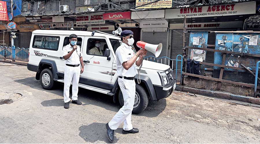 Policemen warn residents along MG Road about the storm.