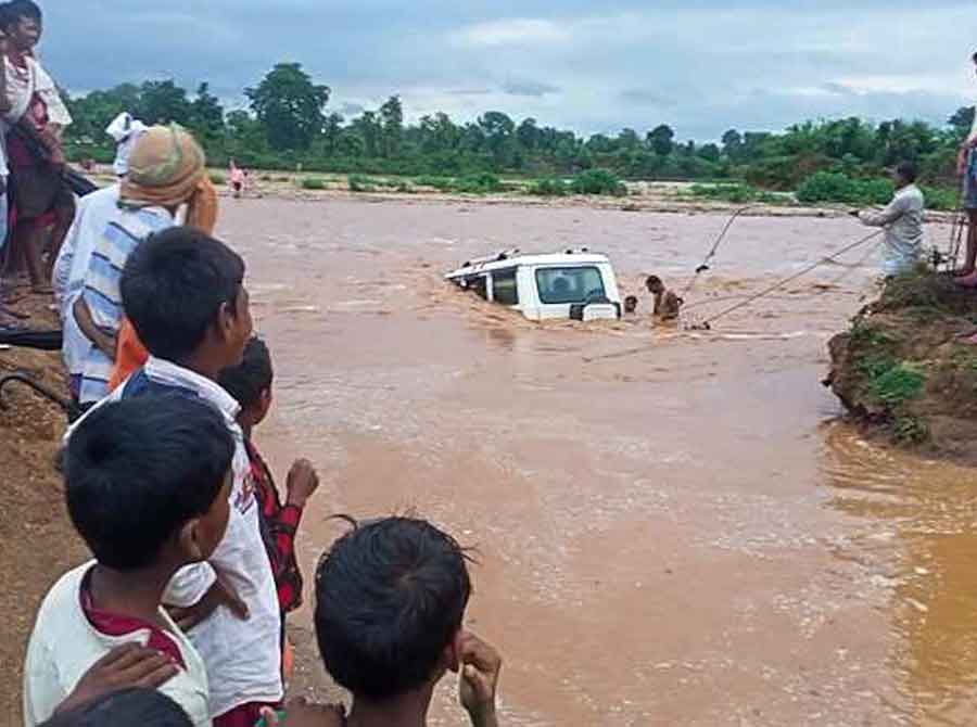 Villagers near Tupu Hesla of Latehar Sadar block rescue passengers stranded in a Bolero submerged in Dhardhari river.