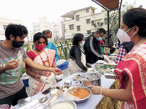 Sumona Jana and her husband Ranadwip, back from Bangalore, sell homemade desserts at a Pithe Puli Utsab in their block.