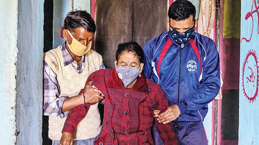 Suresh and his nephew Rajesh Kumar help Pramila to her feet.